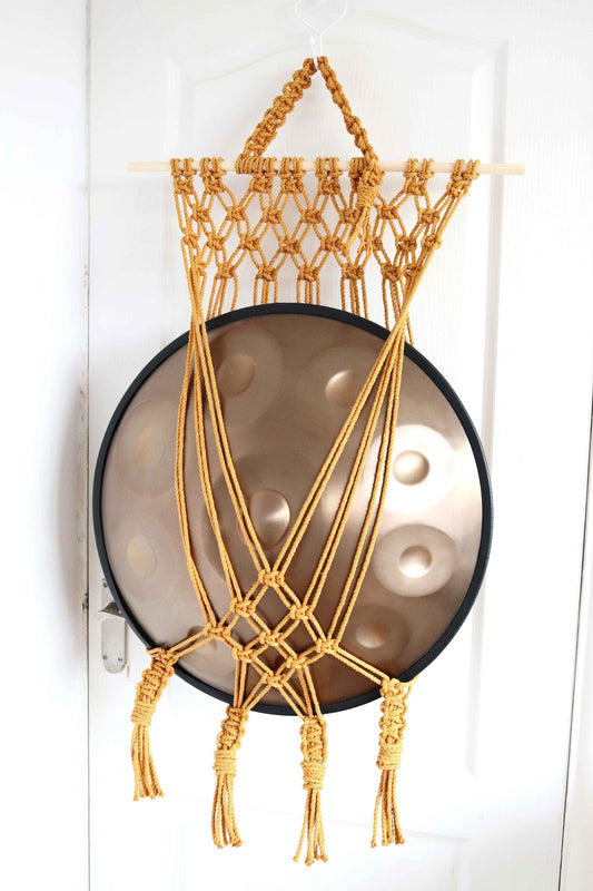 Handmade macrame handpan hanger with a netted design, displaying a handpan Tuning Fork.