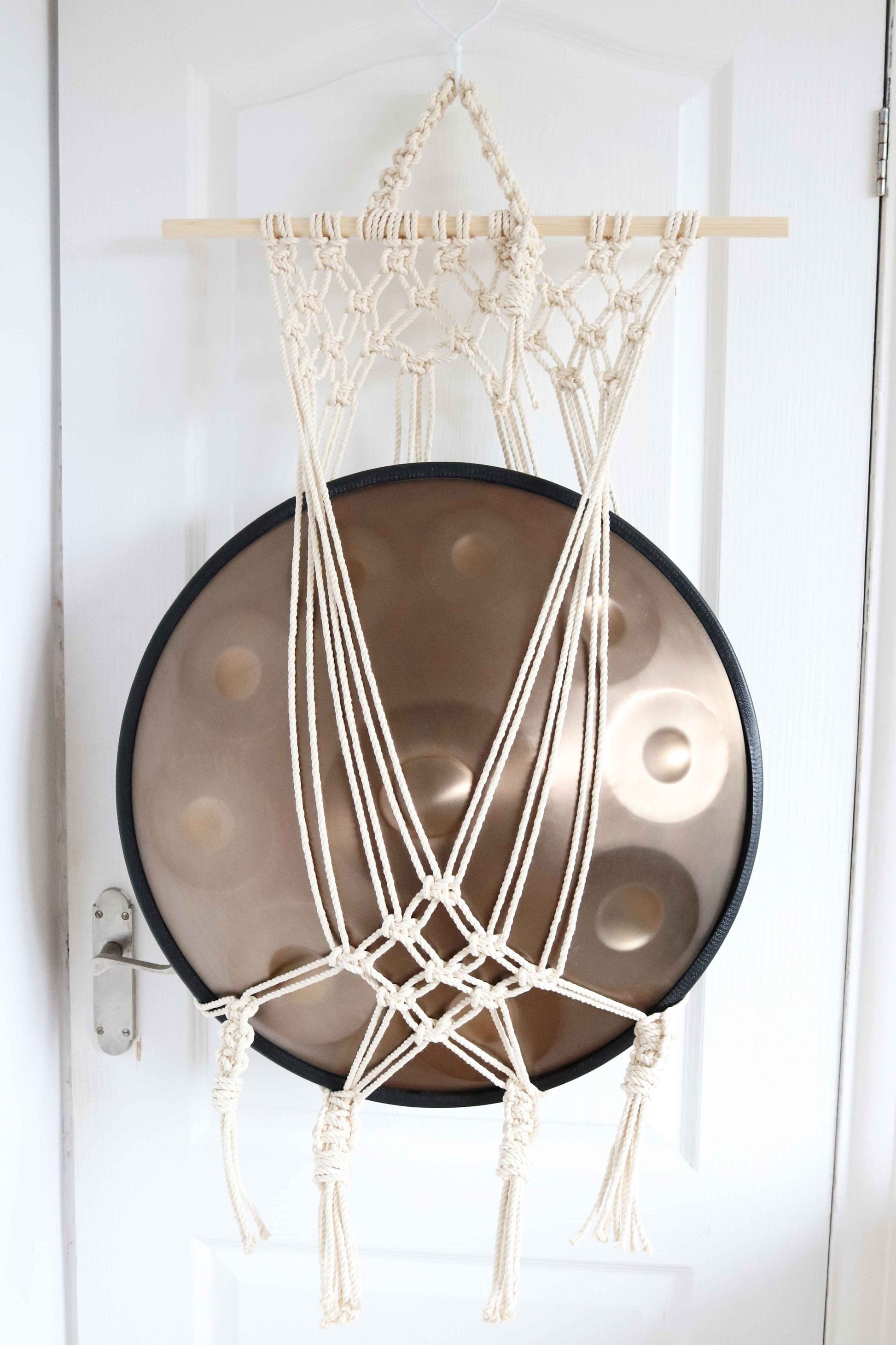 Macrame wall hanging with a round object on a white door