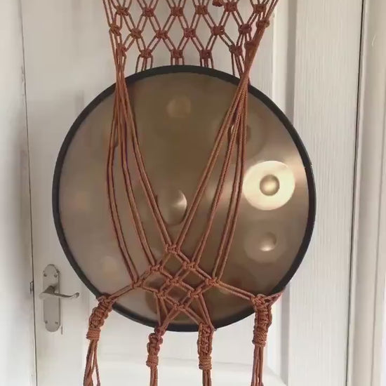 Copper macrame handpan wall mount holding a handpan
