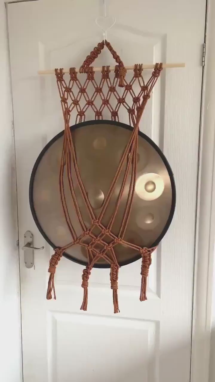 Copper macrame handpan wall mount holding a handpan